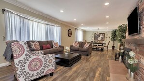 Un salon comprenant un canapé, des fauteuils, une table basse et une cheminée.