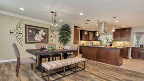 Une cuisine moderne avec des meubles en bois, un îlot central et un coin repas avec une banquette.