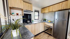 A modern kitchen with wooden cabinets, a stainless steel refrigerator, a built-in oven, and a gas stove.