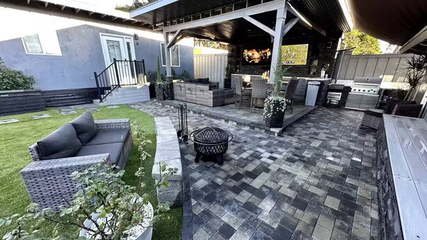 A covered patio area with a stone floor, outdoor furniture, and a grill. - Welcome to SD Cozy Home - B (La Mesa)