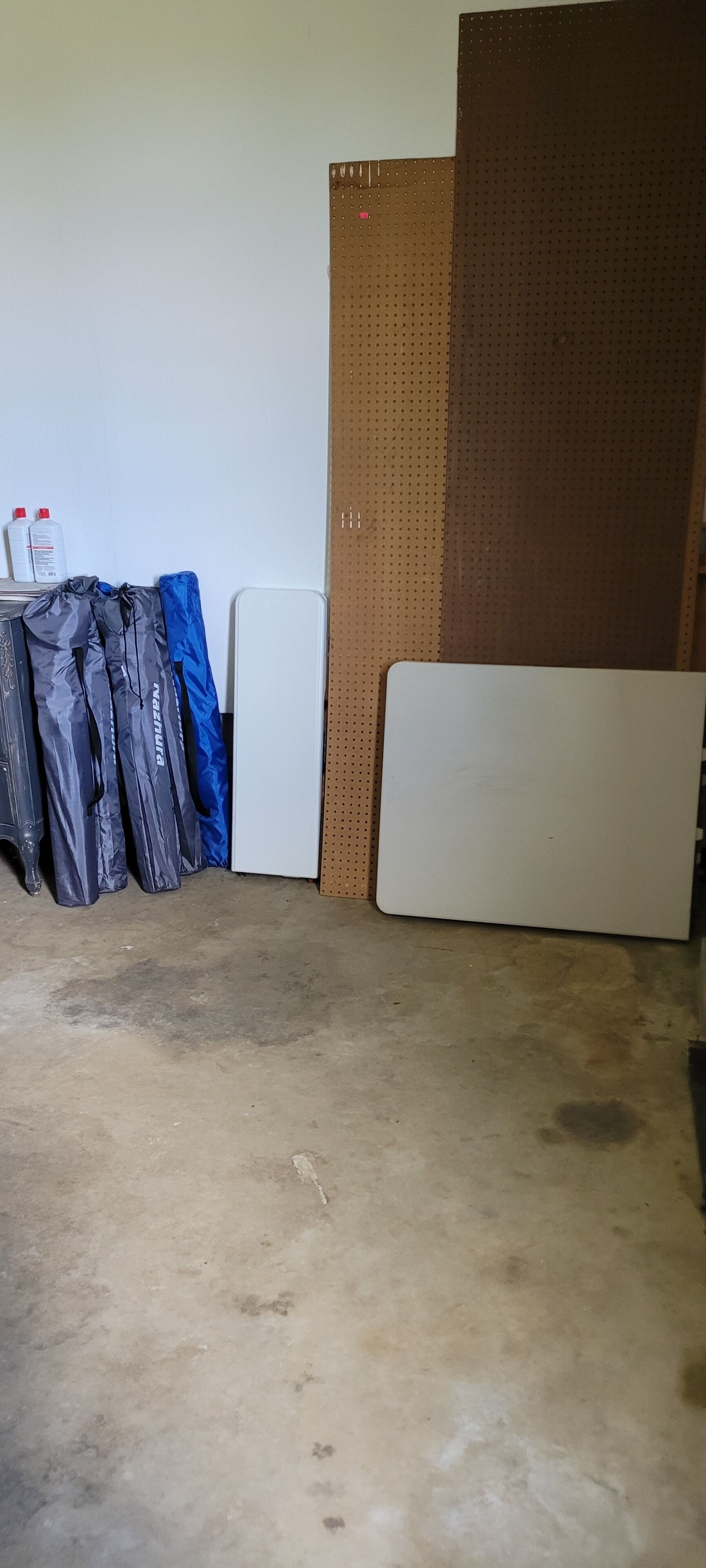 A room with a white door, a brown wall with a perforated pattern, and a whiteboard.