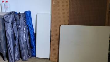 A room with a white door, a brown wall with a perforated pattern, and a whiteboard.