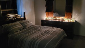 Un dormitorio con una cama, un aparador y un espejo.
