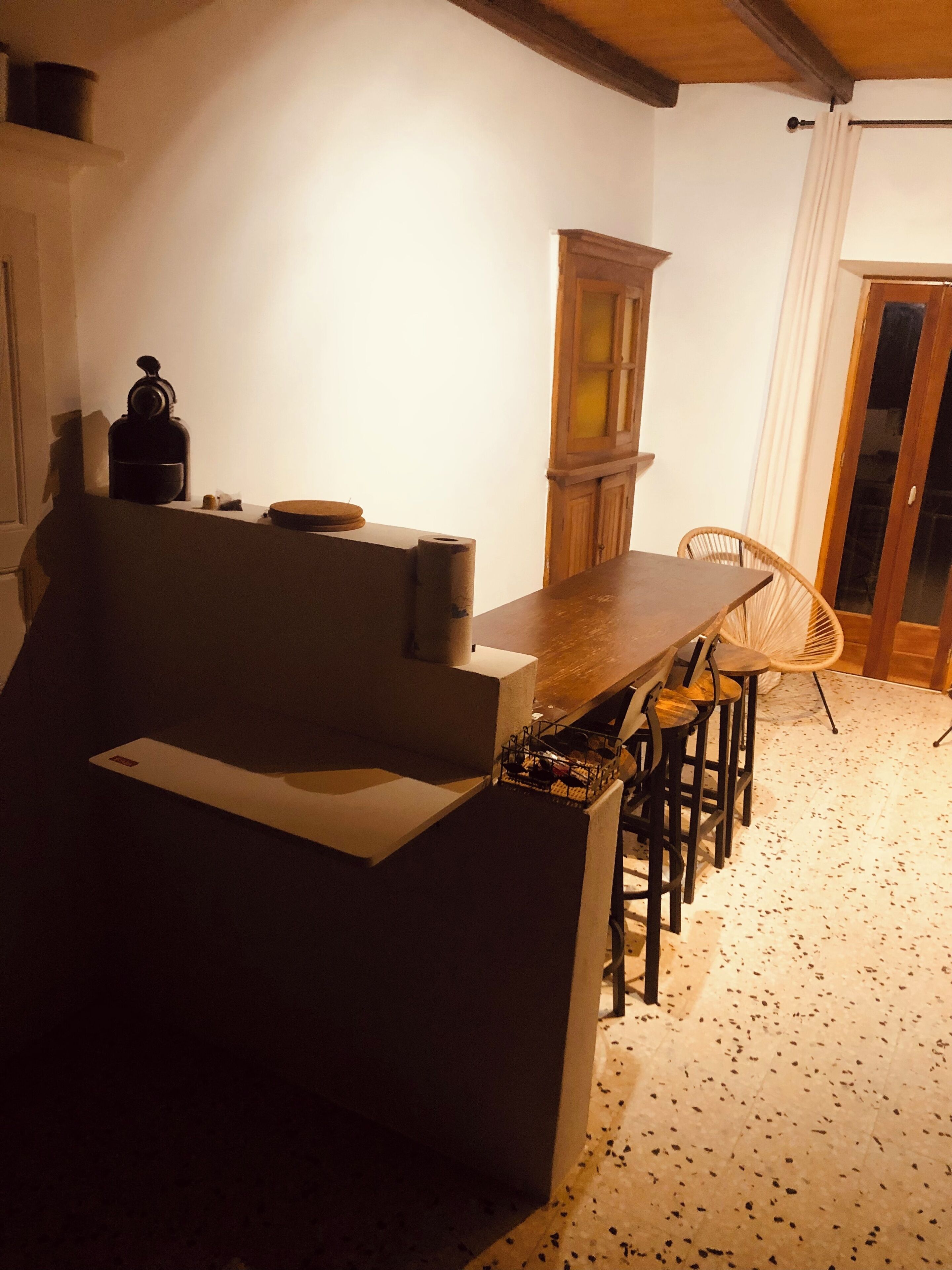 Une cuisine de taille réduite, avec une table et des chaises en bois, un meuble et un plan de travail.