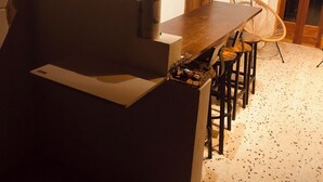 A compact kitchen with a wooden table and chairs, a cabinet, and a countertop.