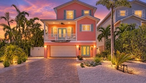 A two-story house with a balcony, a garage, and a driveway.