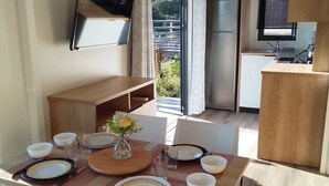 A modern kitchen with a dining area. - ZEcamping 3* espace aquatique mobil-home TV LV BBQ 30m2 (Aigues-Vives)