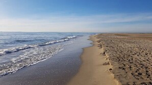 A beach with a sandy shore and waves. - ZEcamping 3* espace aquatique mobil-home TV LV BBQ 30m2 (Aigues-Vives)