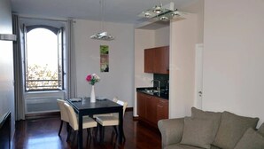 A modern living room with a dining area, a kitchen, and a large window with a view. - ZEcamping 3* locatif TV clim 41m2 4 pers (Saint-Lizier)