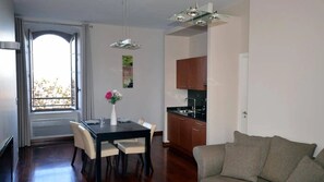 Un salon moderne comprenant un coin repas, une cuisine et une grande fenêtre offrant une vue dégagée.