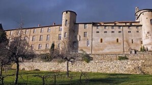A large, historic building with multiple towers and a stone wall. - ZEcamping 3 étoiles pet friendly locatif TV clim 48m2 6 pers (Saint-Lizier)