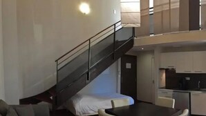 A compact living space with a bed, a dining table, and a kitchenette. - ZEcamping 3 étoiles pet friendly locatif TV clim 48m2 6 pers (Saint-Lizier)