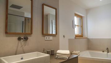 Ein modernes Badezimmer mit zwei Waschbecken, einem großen Spiegel und einem Fenster.