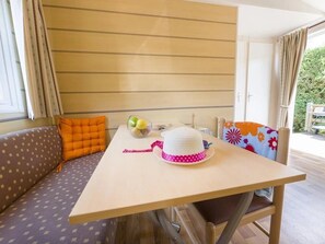 Un espace repas comprenant une table, des chaises et un banc.
