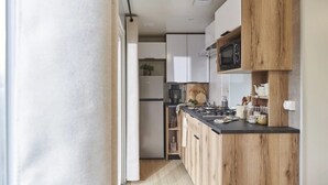 Eine moderne Küche mit Holzausstattung, einer schwarzen Arbeitsplatte und einer Mikrowelle.