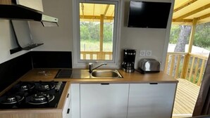 Eine kleine Küche mit Gaskochfeld, Spüle, Kaffeemaschine und Toaster.