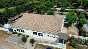 A building with a tiled roof and a sign reading "LE PINADA". - ZEcamping 3* animé toboggans animaux acceptés locatif TV LV BBQ 31m2 (Fabrezan)