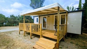A wooden deck with a covered area and a small attached building. - ZEcamping 3* animé toboggans animaux acceptés locatif TV LV BBQ 31m2 (Fabrezan)
