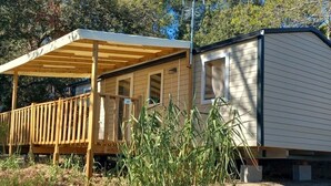 A mobile home with a covered porch and a small window.