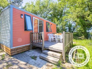 A mobile home with a deck, outdoor seating, and a wooden staircase. - ZEcamping 4* avec animaux acceptés piscine chauffée à 4km de la plage (Argeles-sur-Mer)