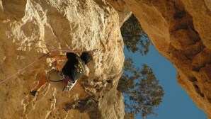 Une personne qui descend une falaise rocheuse en rappel.