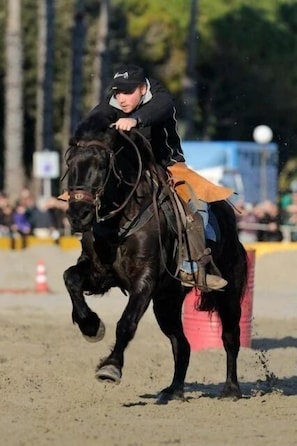 Une personne à cheval dans une arène en plein air.