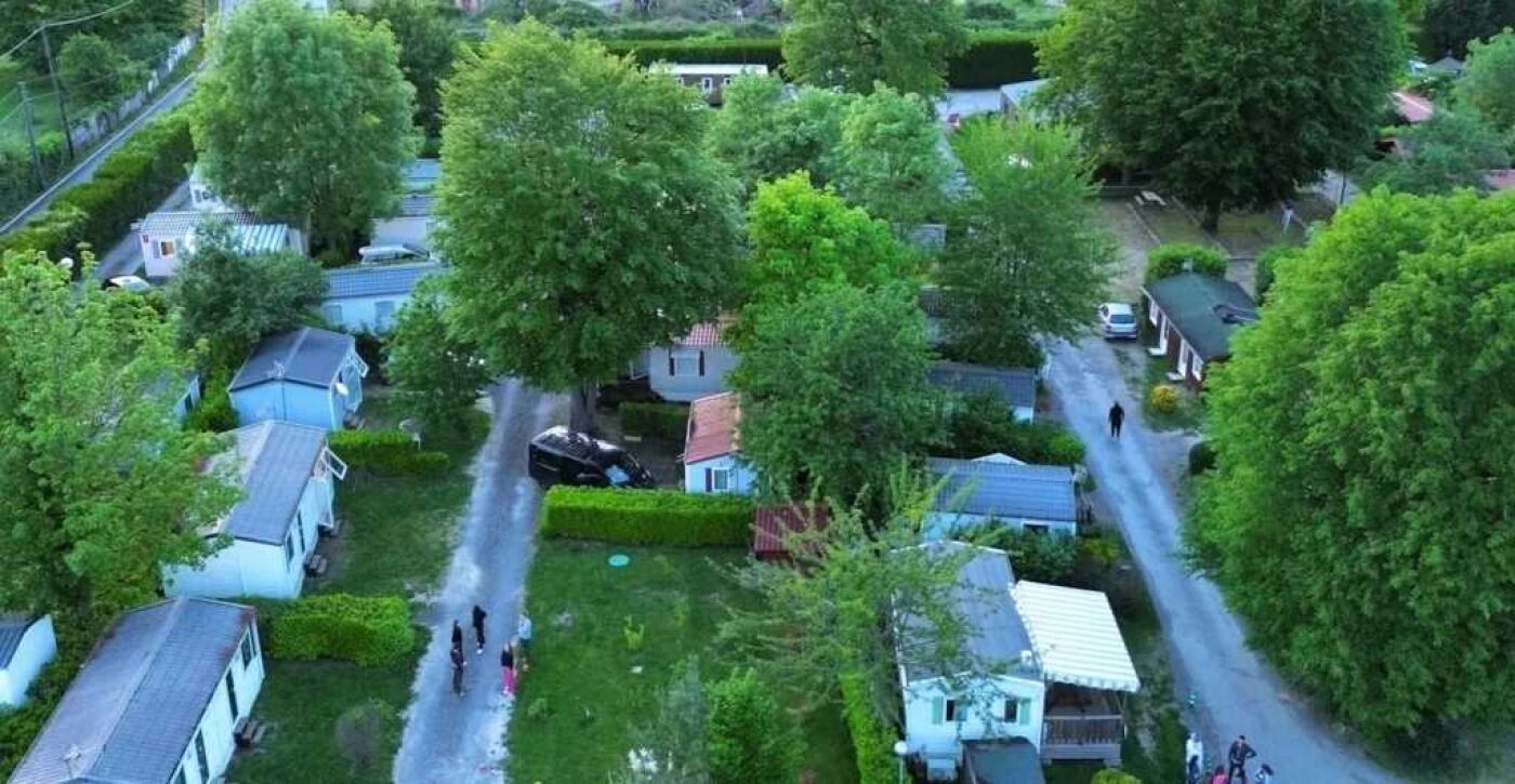Vista aérea de una zona residencial con casas, árboles y una carretera.