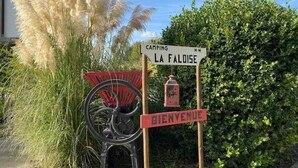 Un cartel de bienvenida con un letrero de camping y una rueda de bicicleta.
