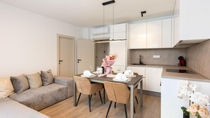 A modern apartment with a dining area, a sofa, and a kitchen. - Amazing apartment in Podstrana with WiFi (Podstrana)