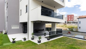 A modern two-story house with a balcony, a covered outdoor seating area, and a well-maintained lawn. - Amazing apartment in Podstrana with WiFi (Podstrana)