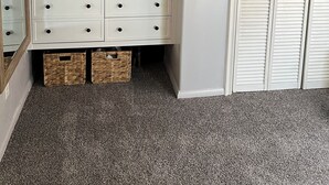 Habitación con un aparador blanco, un espejo y una puerta blanca. Hay estantes sobre el aparador con objetos decorativos.