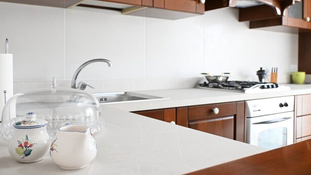 A kitchen with a white countertop, wooden cabinets, a stainless steel sink, and a stove. - S347 – Sirolo, delightful two-room apartment with balcony (Sirolo)