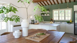 A kitchen with wooden beams, a large window, and a dining table with a cutting board and utensils. - Awesome home in Massa e Cozzile (Massa e Cozzile)
