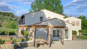 A two-story building with a covered patio area, stone walls, and a gravel driveway. - Awesome home in Massa e Cozzile (Massa e Cozzile)
