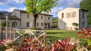 A two-story building with a garden in front, a pergola, and a wooden fence. - Awesome home in Massa e Cozzile (Massa e Cozzile)