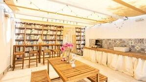 Un coin lecture confortable avec des étagères, une table en bois et un espace cuisine agrémenté de carreaux décoratifs.