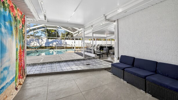 Ein moderner Außenbereich mit Pool, Sitzgelegenheiten und einem farbenfrohen Wandgemälde.