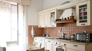 Una cocina con estufa, microondas y armarios.