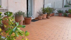 Un patio con plantas en macetas y suelo de ladrillo.