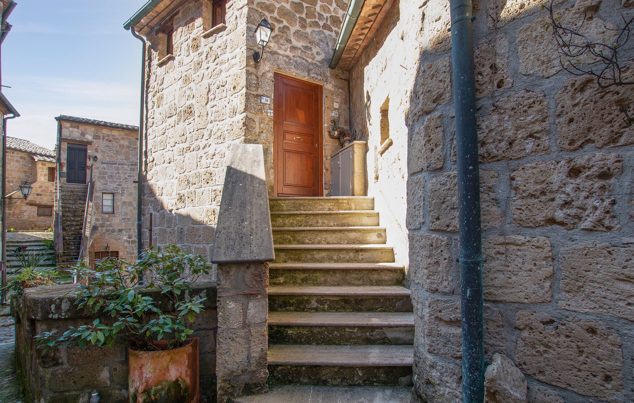 Un edificio de piedra con una puerta de madera y una escalera que lleva a la entrada.