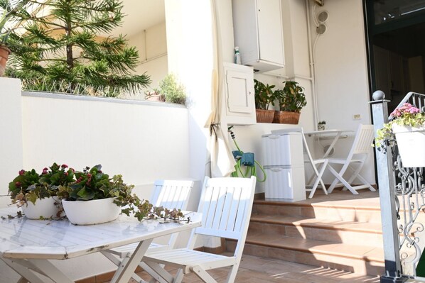A patio with a table and chairs, potted plants, and a small tree. - P050 - Porto Recanati, elegant three-room apartment in the historic center (Porto Recanati)
