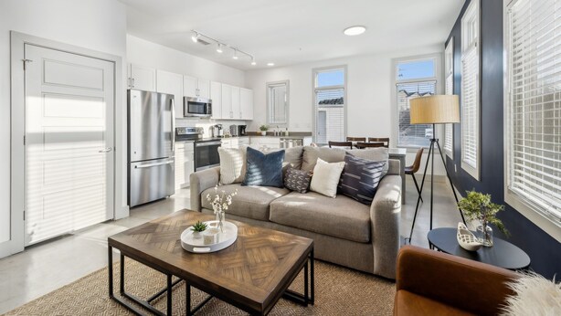 A modern apartment with a kitchen, living area, and dining space.