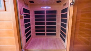 Una sauna con interior de madera, una luz en el techo y una puerta con picaporte.