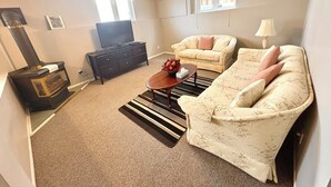 Un salon avec une cheminée, un canapé, une table basse et un téléviseur.