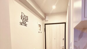 Un couloir doté d’un plancher de couleur claire, une porte au fond et un mur orné d’une citation inspirante.