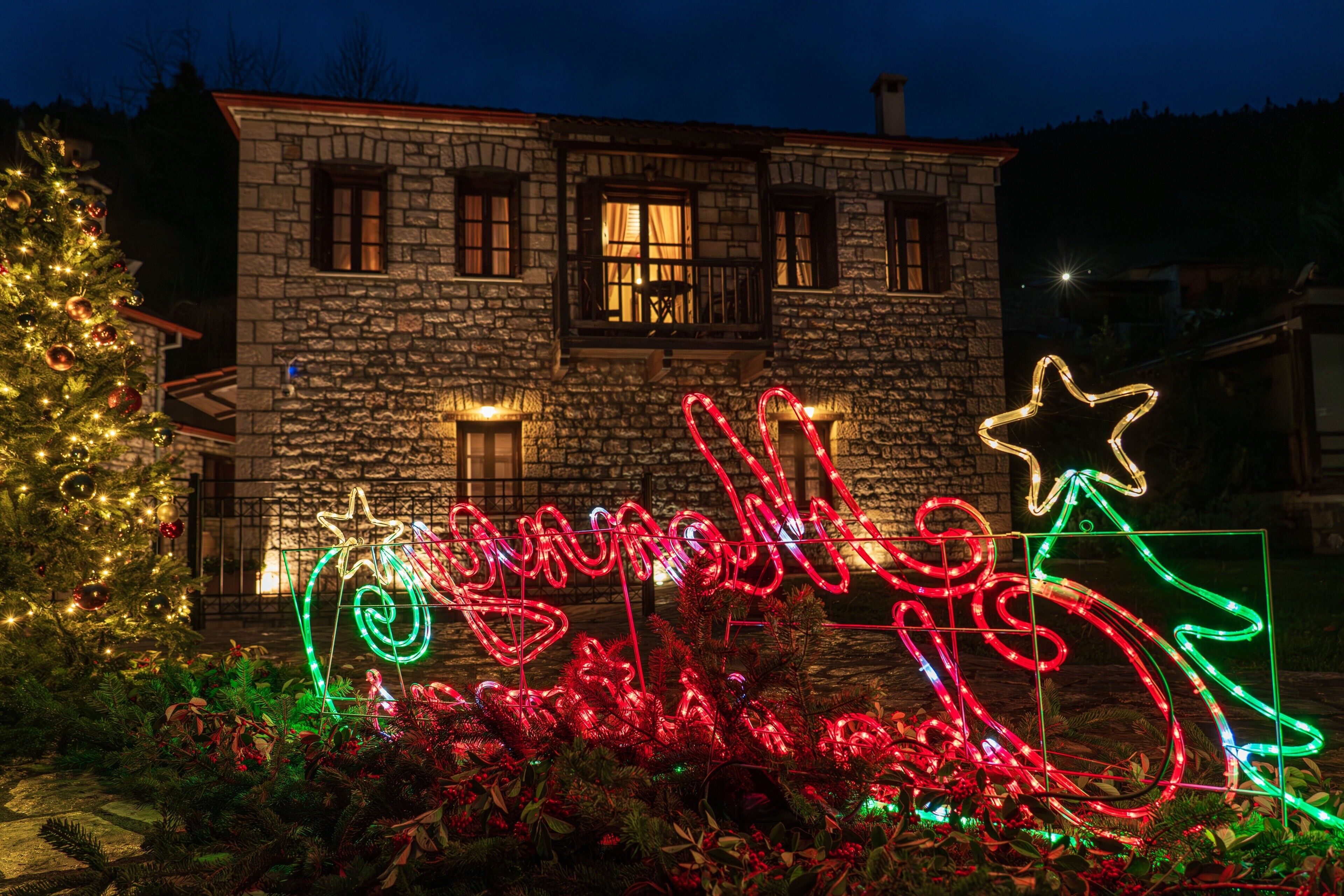 Een stenen gebouw met een kerstboom en verlichte decoraties.