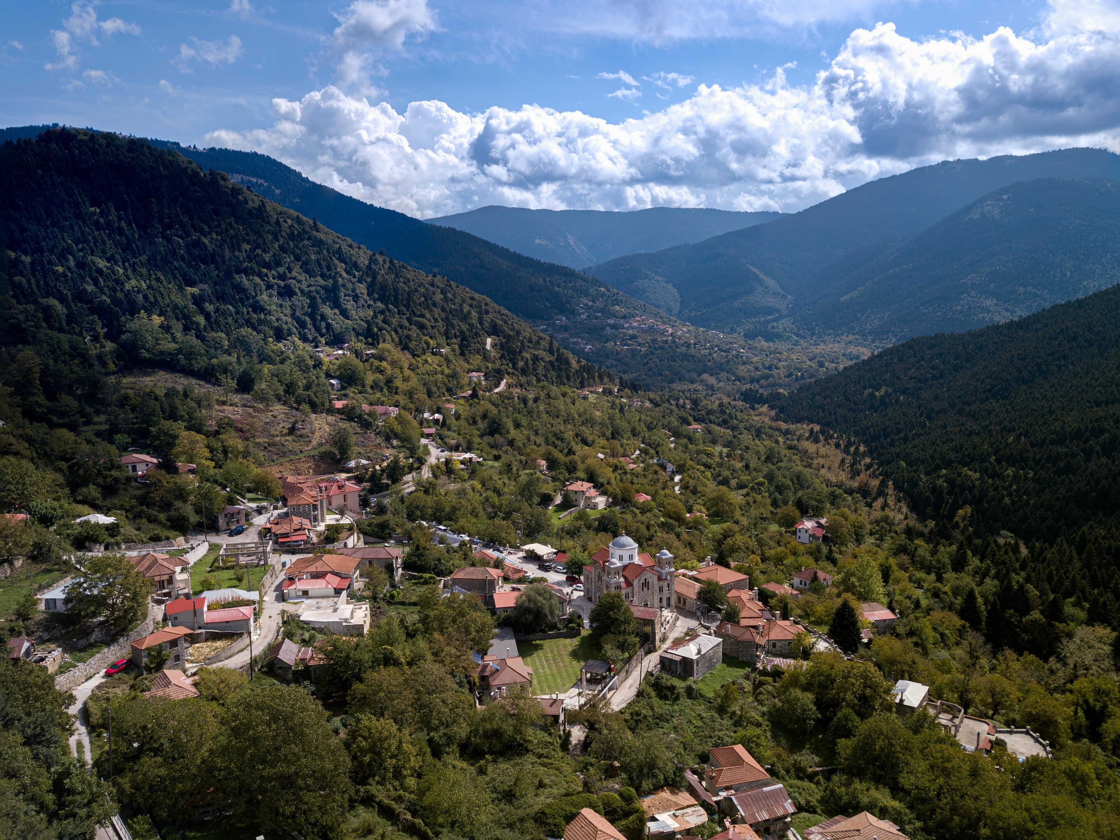 Ein Dorf mit Häusern, einer Kirche und Bergen im Hintergrund.