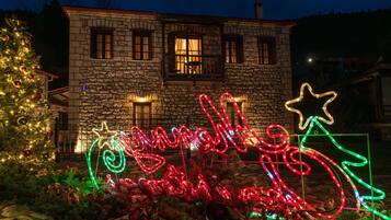 A stone building with a Christmas tree and illuminated decorations.