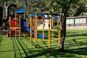 A playground with a slide and climbing structures.