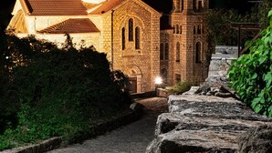 Eine Steinkirche mit Glockenturm und Kuppel, beleuchtet bei Nacht.